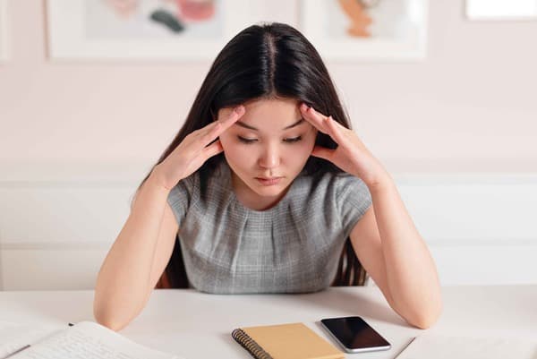 Woman looking stressed, illustrating the connection between stress and tinnitus exacerbation.